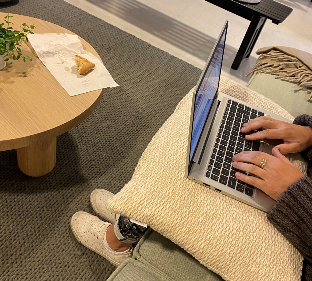 Kvinna sitter med laptop i knät och chattar
